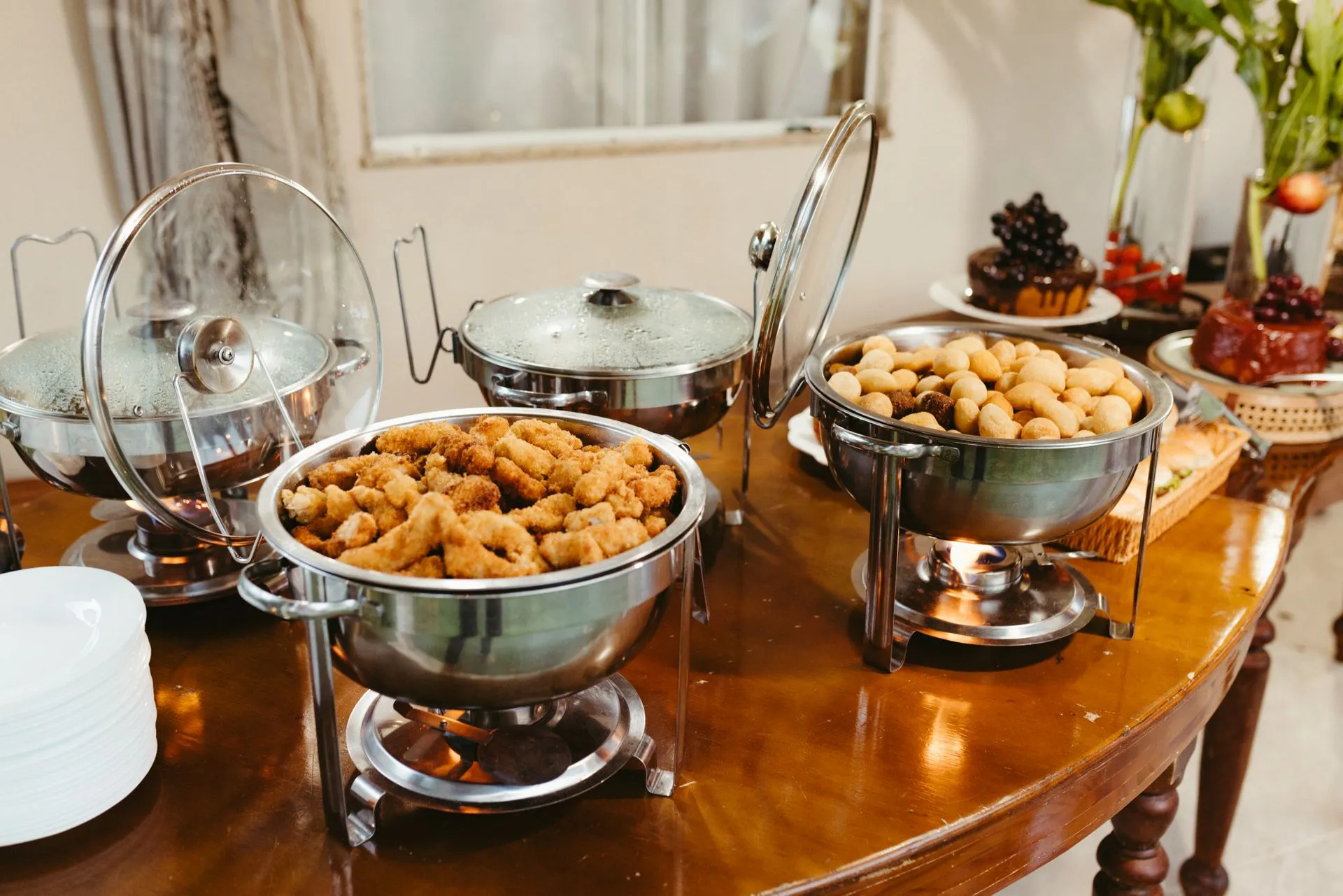 Stainless steel chafing dishes serving warm finger foods and appetizers at a catered event